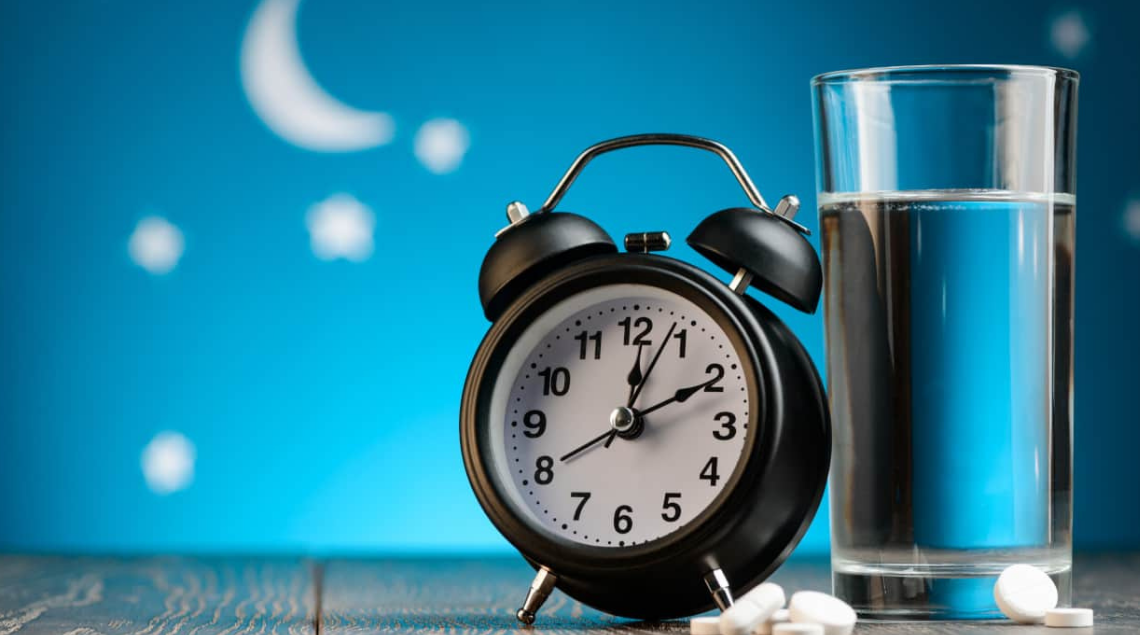 orologio sveglia e un bicchiere di acqua